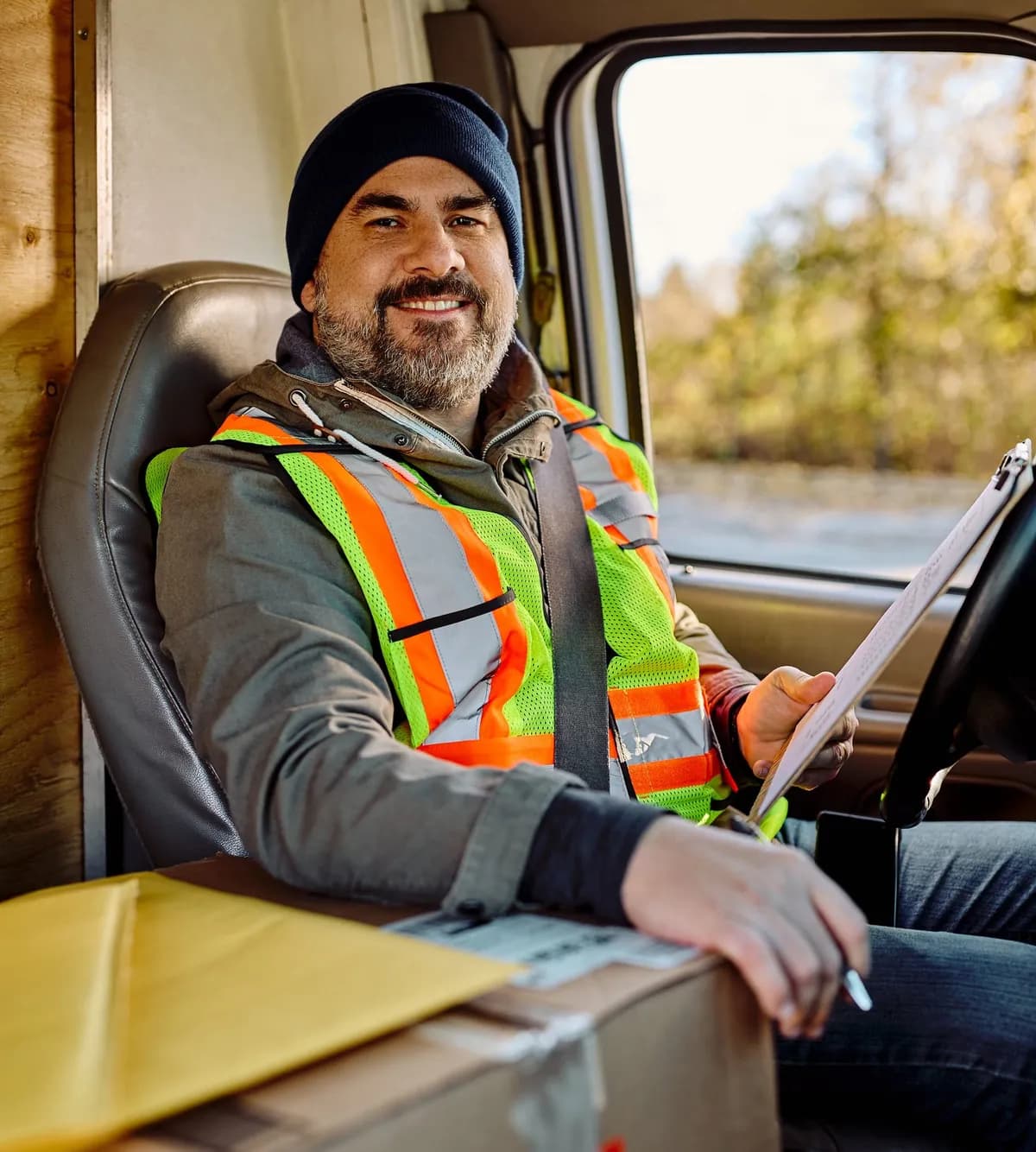 Box truck driver in the cab with a delivery clipboard